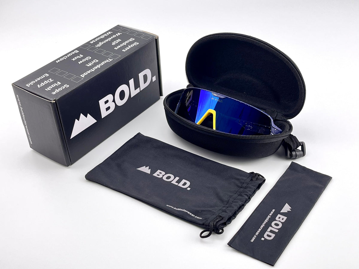 BOLD Shadows wrap sunglasses in blue and yellow with the BOLD box, zip case and cleaning pouch