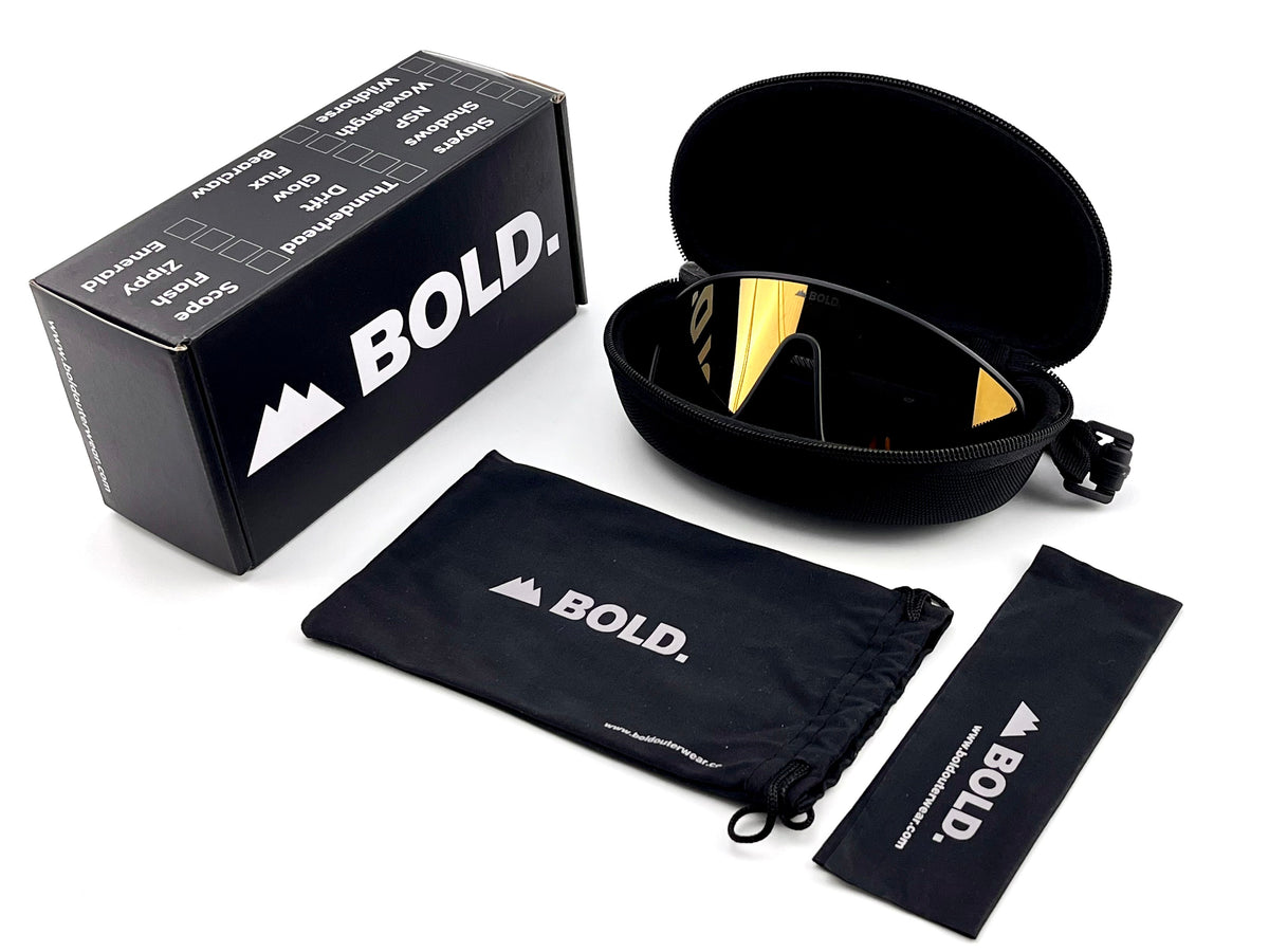 BOLD NSP low-profile sunglasses in gold with the BOLD box, zip case and cleaning pouch