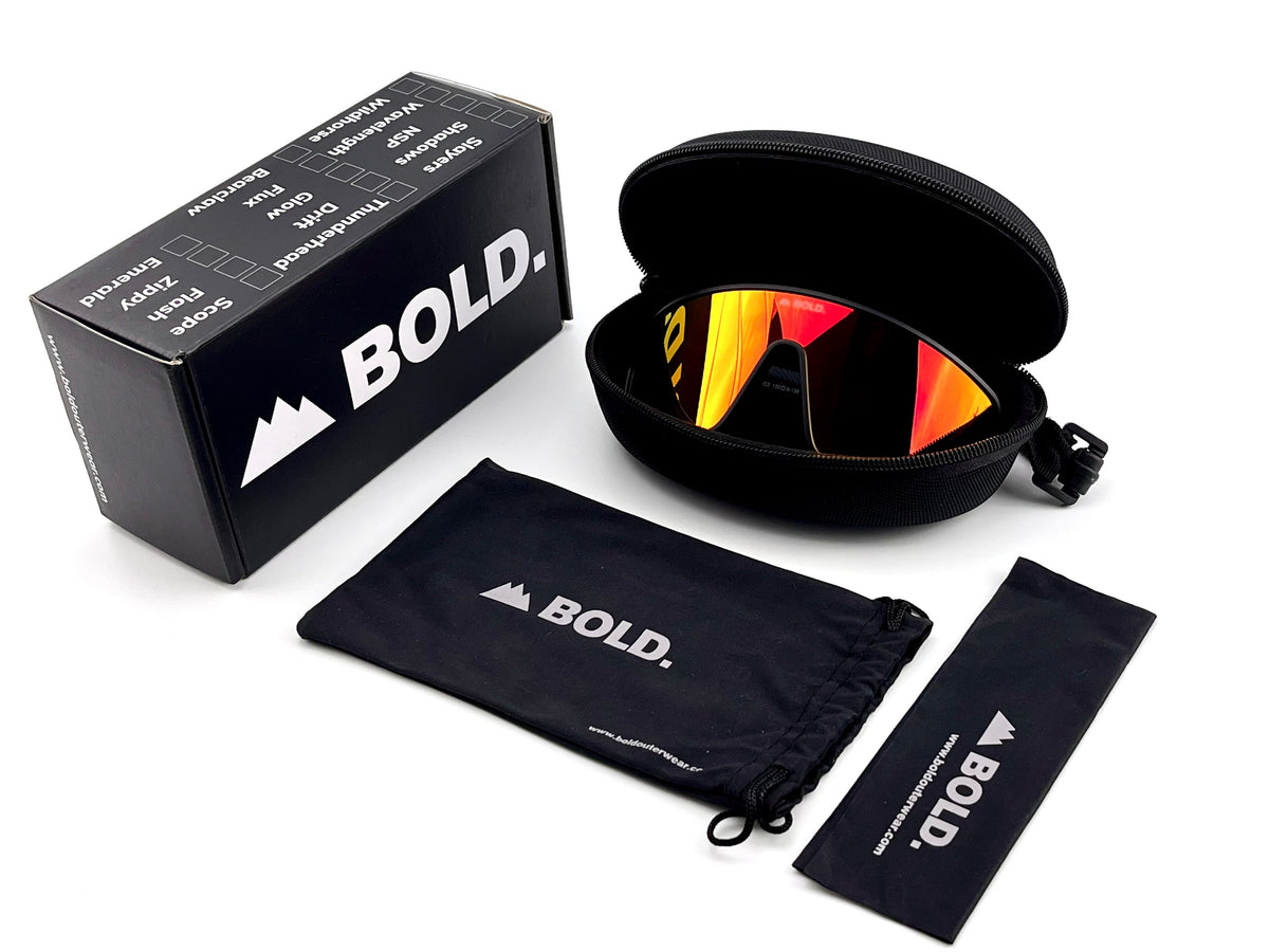 BOLD NSP low-profile sunglasses in red and black with the BOLD box, zip case and cleaning pouch