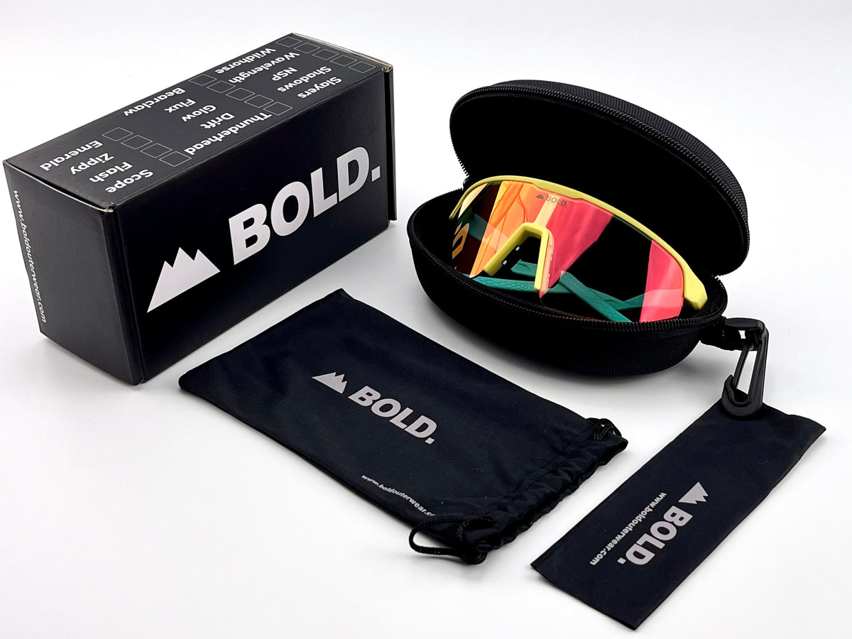 BOLD Flash photochromic sunglasses in blue and yellow with the BOLD box, zip case and cleaning pouch