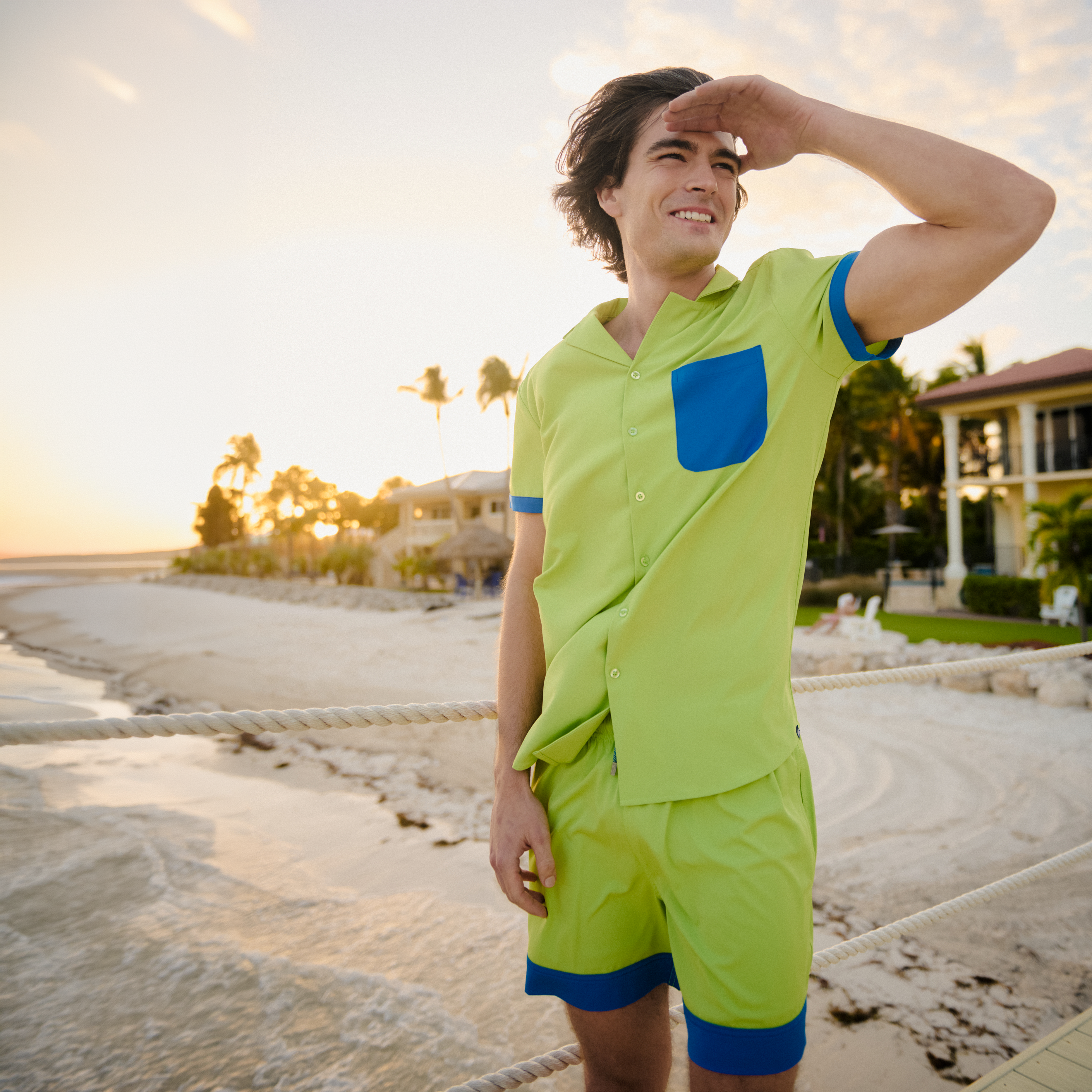 Man in a Key Lime resort shirt worn open over matching lime hybrid swim shorts