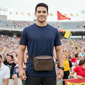 Man wearing a brown fanny pack at a sports event with a crowd in the background