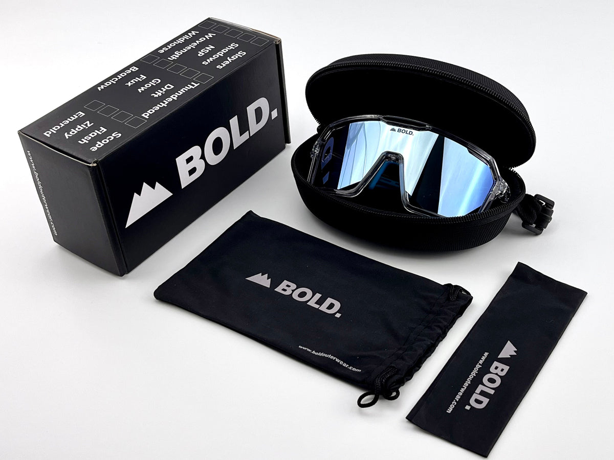 BOLD Flux wrap sunglasses in blue with the BOLD box, zip case and cleaning pouch