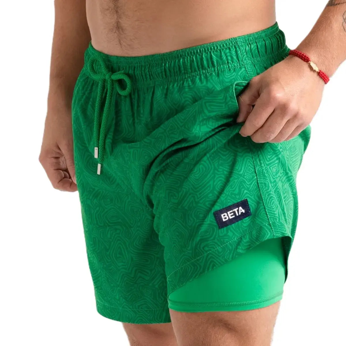Beta Green men's hybrid swim short in solid green with a tonal texture and a woven Beta label at the leg, front view showing the green compression liner