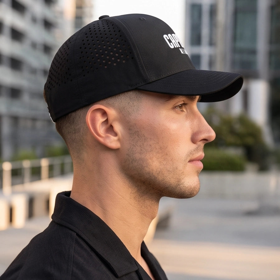 Black Onyx Laser Luxe Performance Snapback Hat worn in profile showing laser perforated panels and curved visor, Capelle Miami