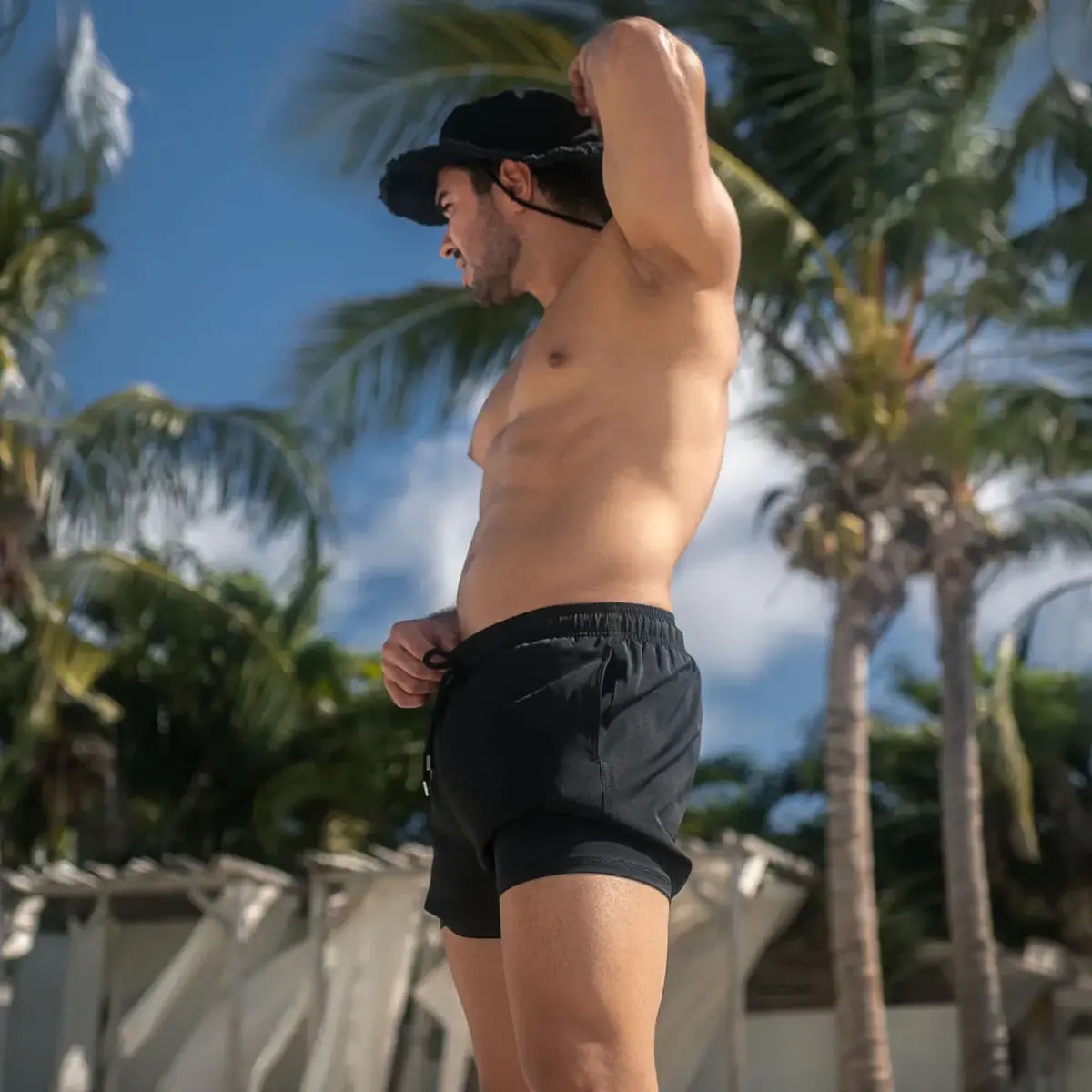 Man in Black Onyx hybrid swim shorts in the 3 inch Short, solid black, outdoors