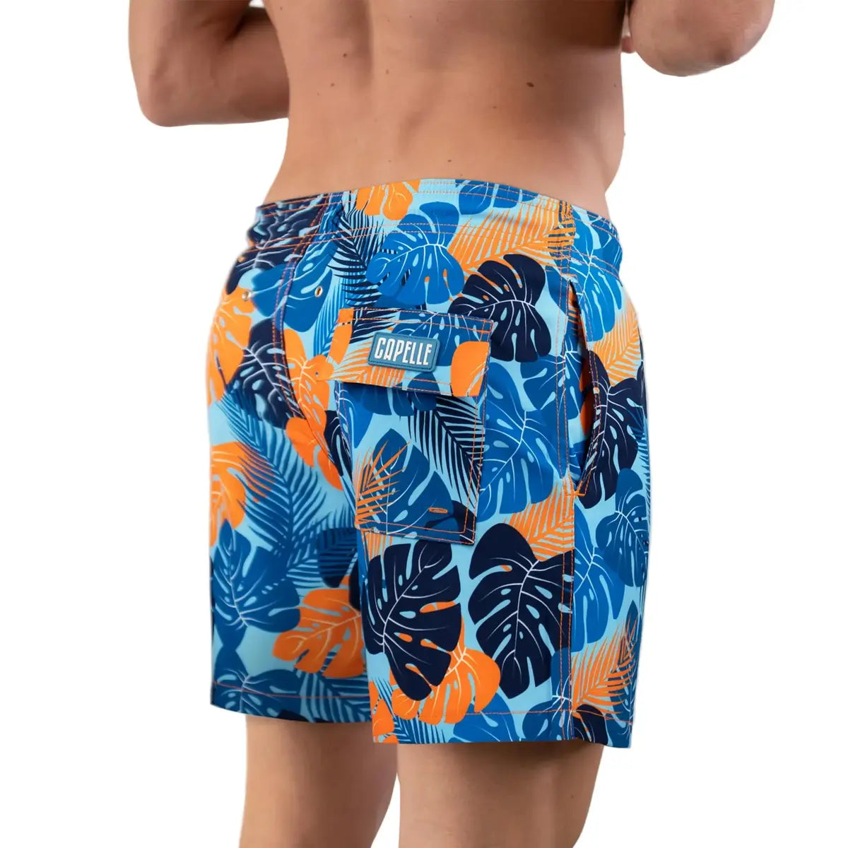 Blue Jungle men's hybrid swim short in a blue and orange tropical leaf print, back view