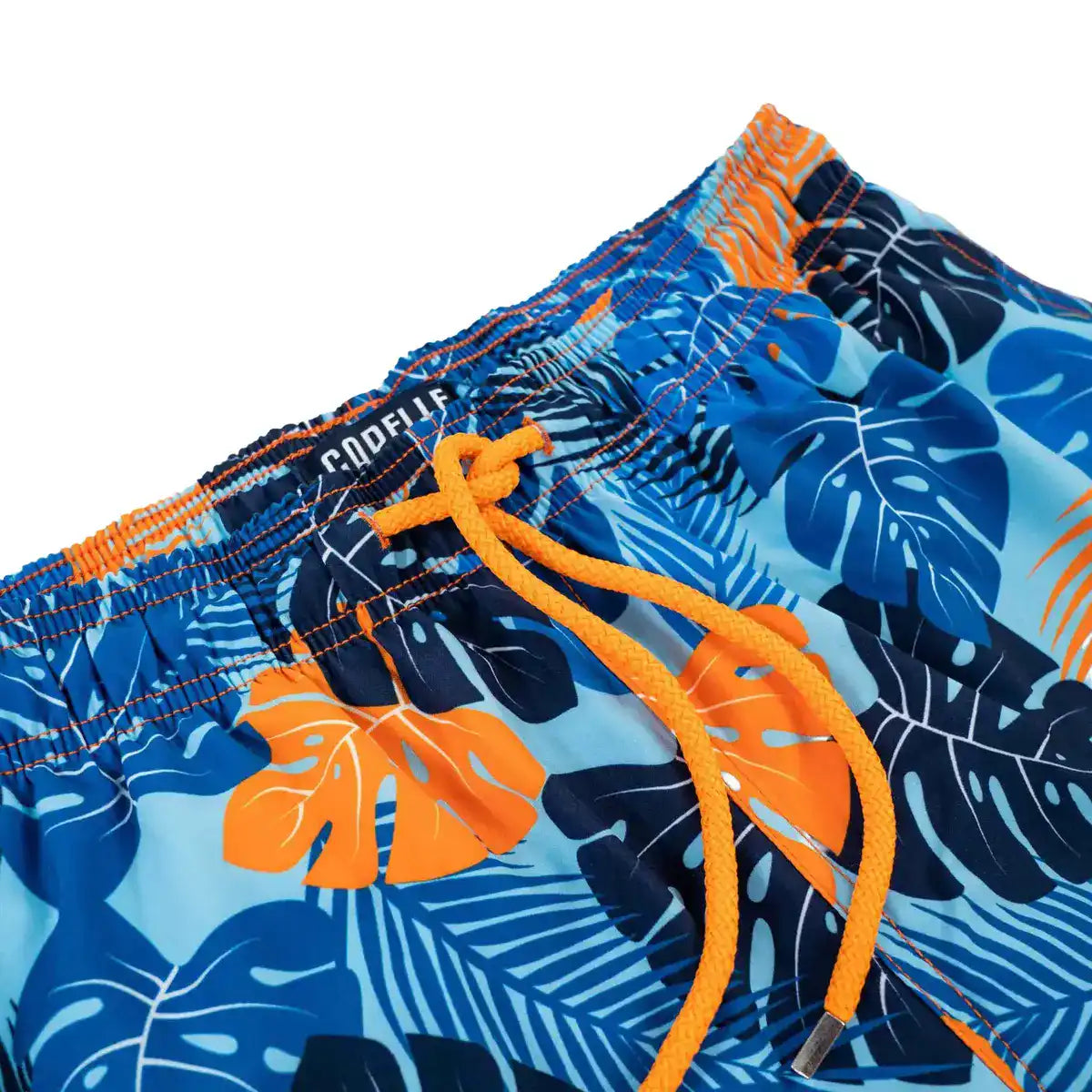 Close-up of the Blue Jungle quick-dry fabric, blue and orange tropical leaf print with contrast stitching