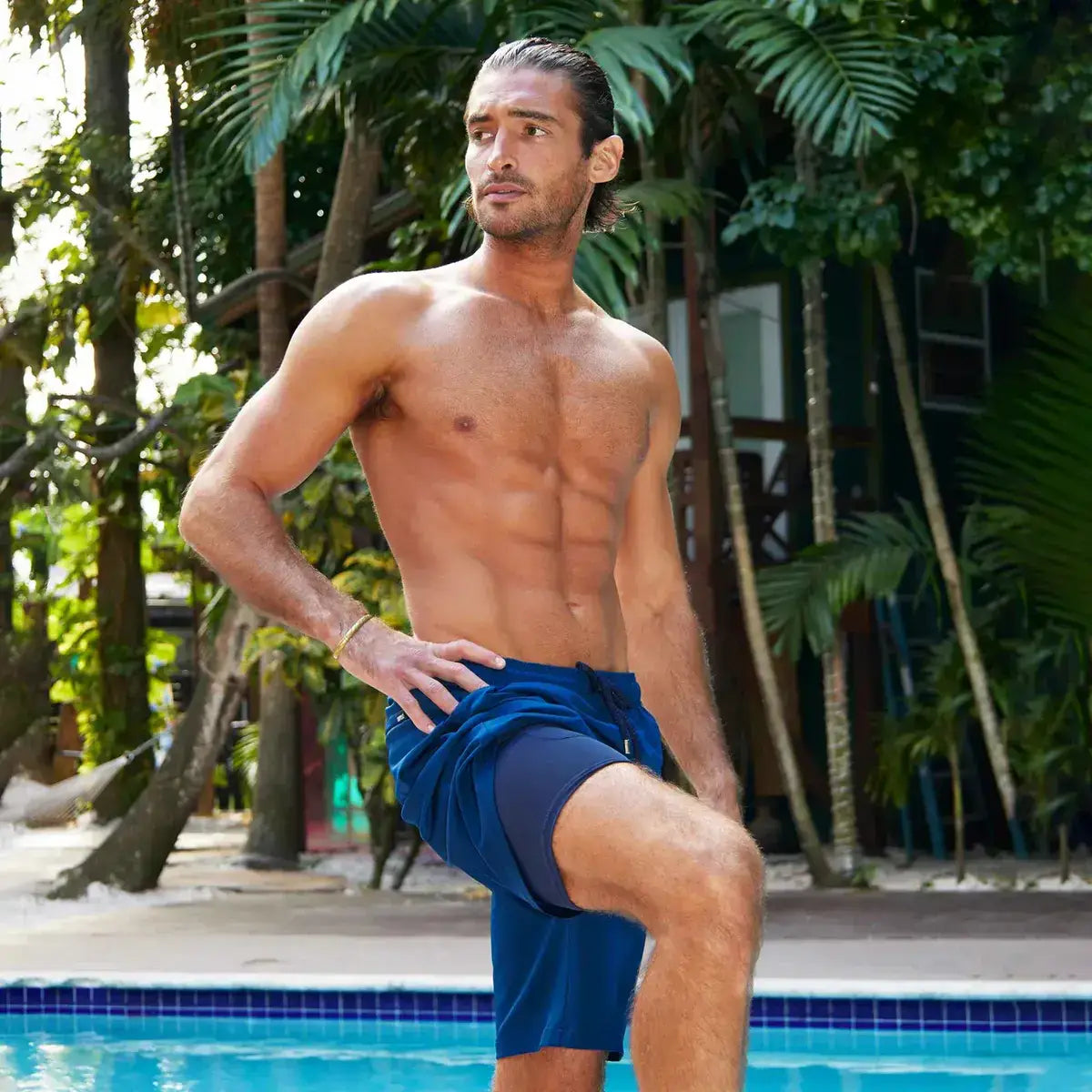 Man in Blue Sapphire hybrid swim shorts in the 9 inch Long, solid royal blue, outdoors