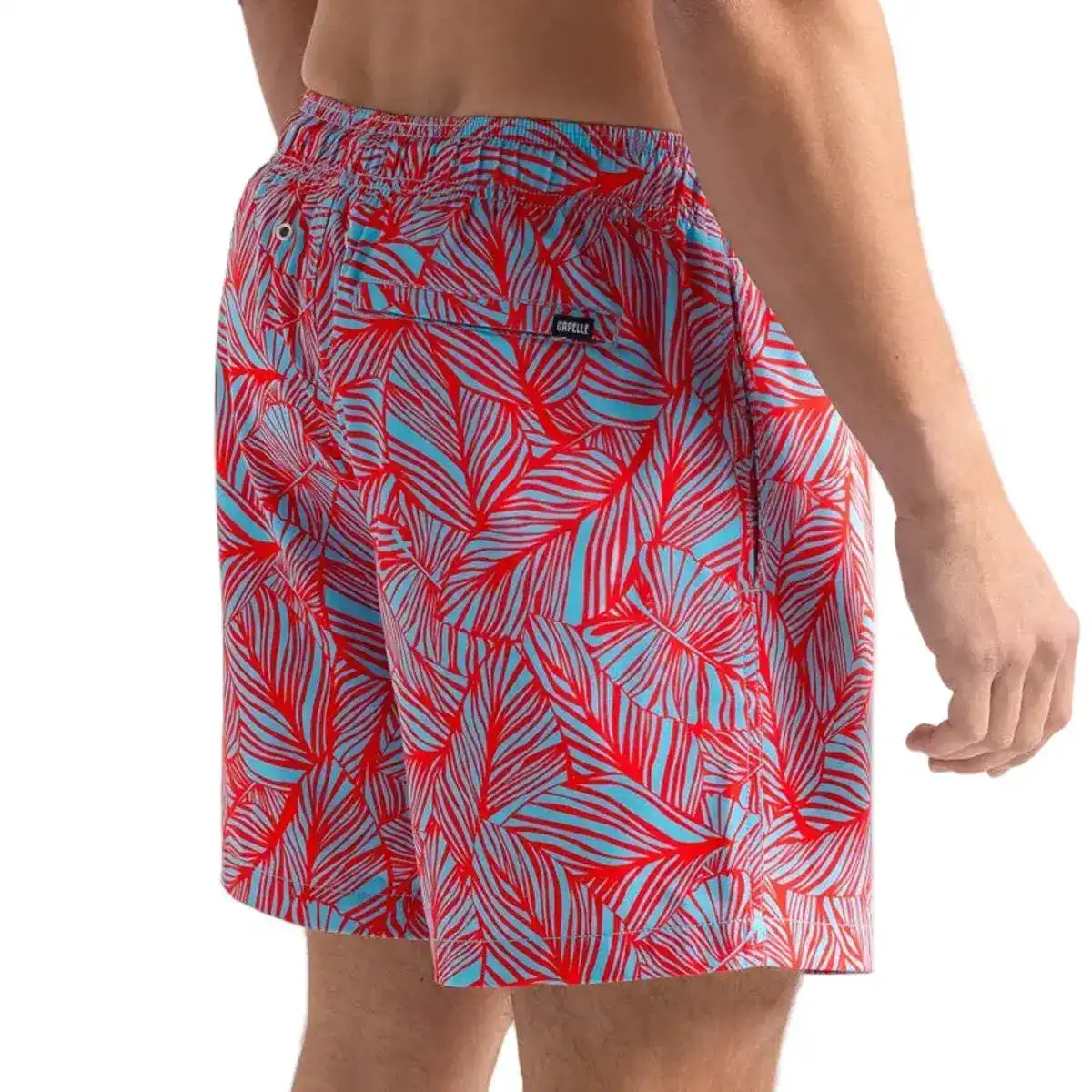 Captive men's hybrid swim short in a coral and pale blue tropical leaf print, back view