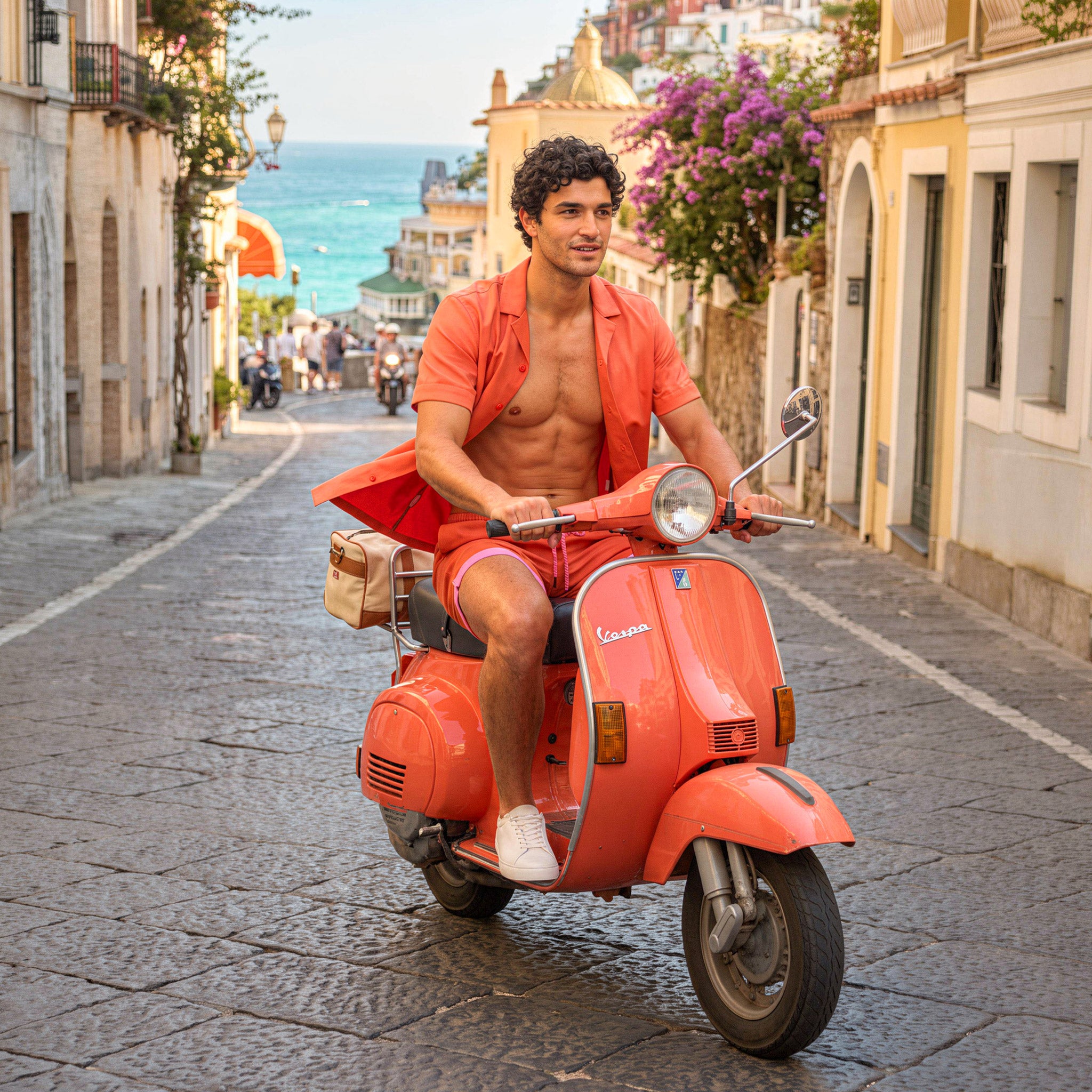 Man beside a red scooter on a village street, in a Coral resort shirt and matching coral shorts