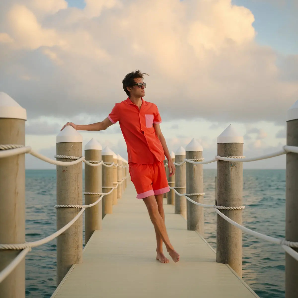 Man in a Coral Flame resort shirt worn open over matching Coral Flame hybrid swim shorts