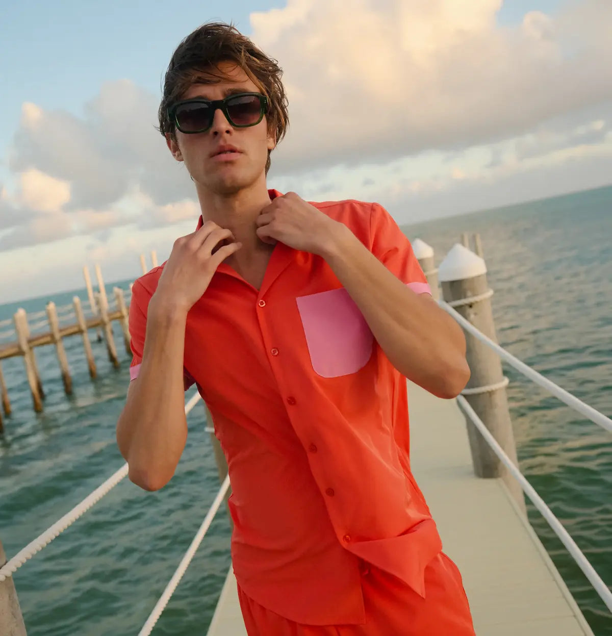 Man in a Coral Flame resort shirt in coral orange with contrast pink trim