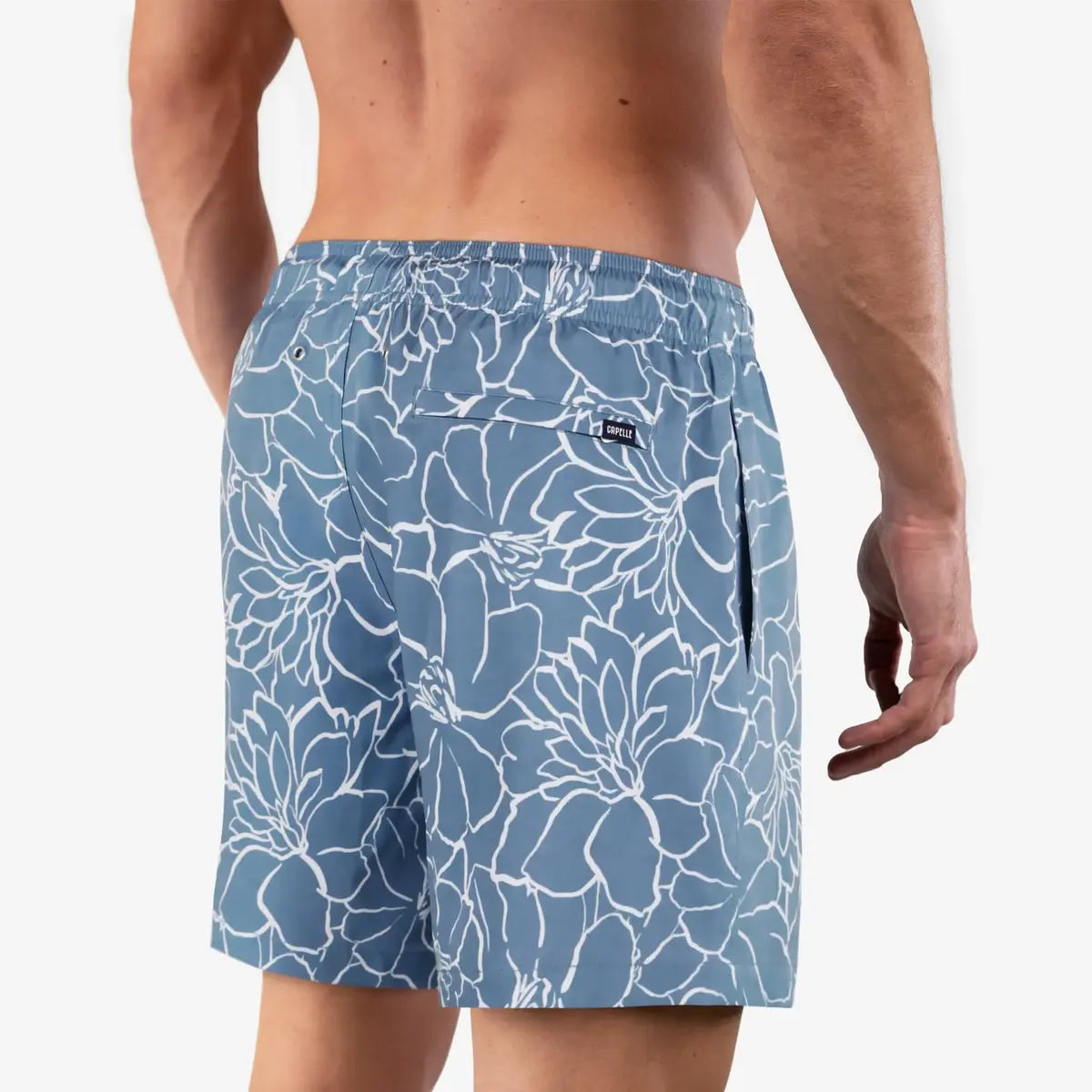 Early Bloom men's hybrid swim short in dusty blue with a white floral outline print, back view
