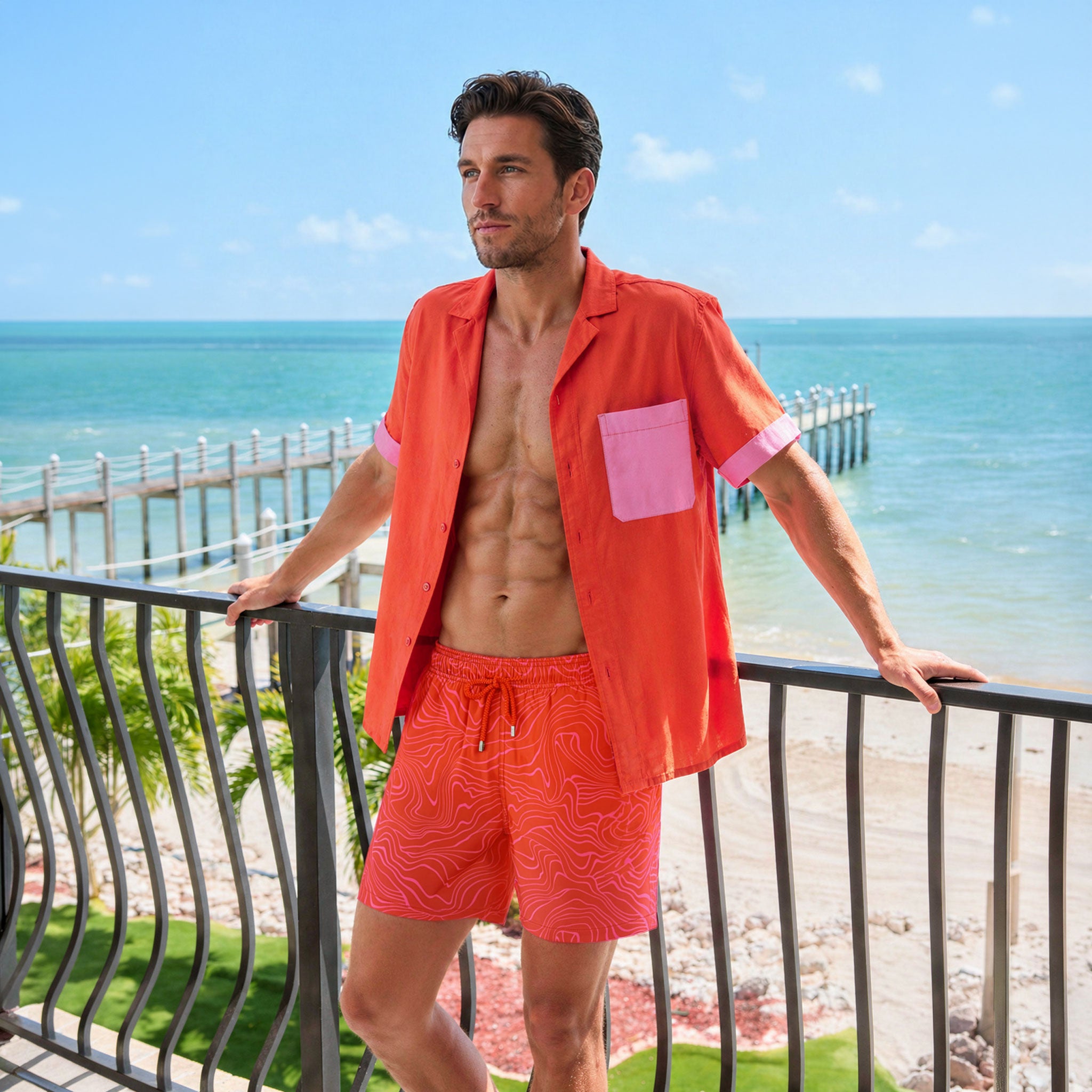 Man in a Coral Flame resort shirt worn open over Sand Waves Heat and Bloom hybrid swim shorts