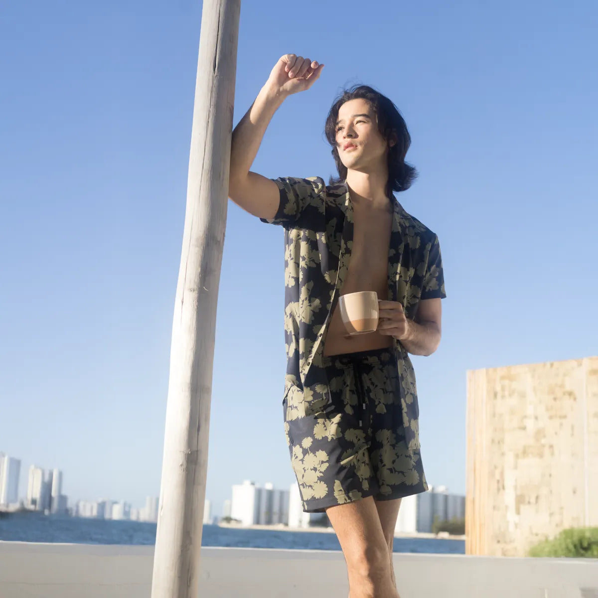 Man against a column in a Foliage resort shirt and matching navy and olive hybrid swim shorts