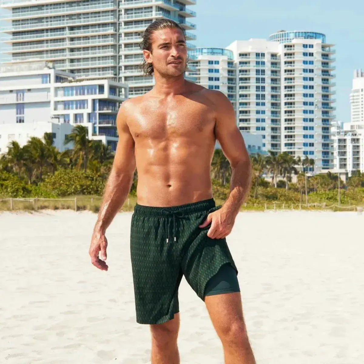 Man in Ipanema hybrid swim shorts in the 9 inch Long, dark green with a tonal scalloped print