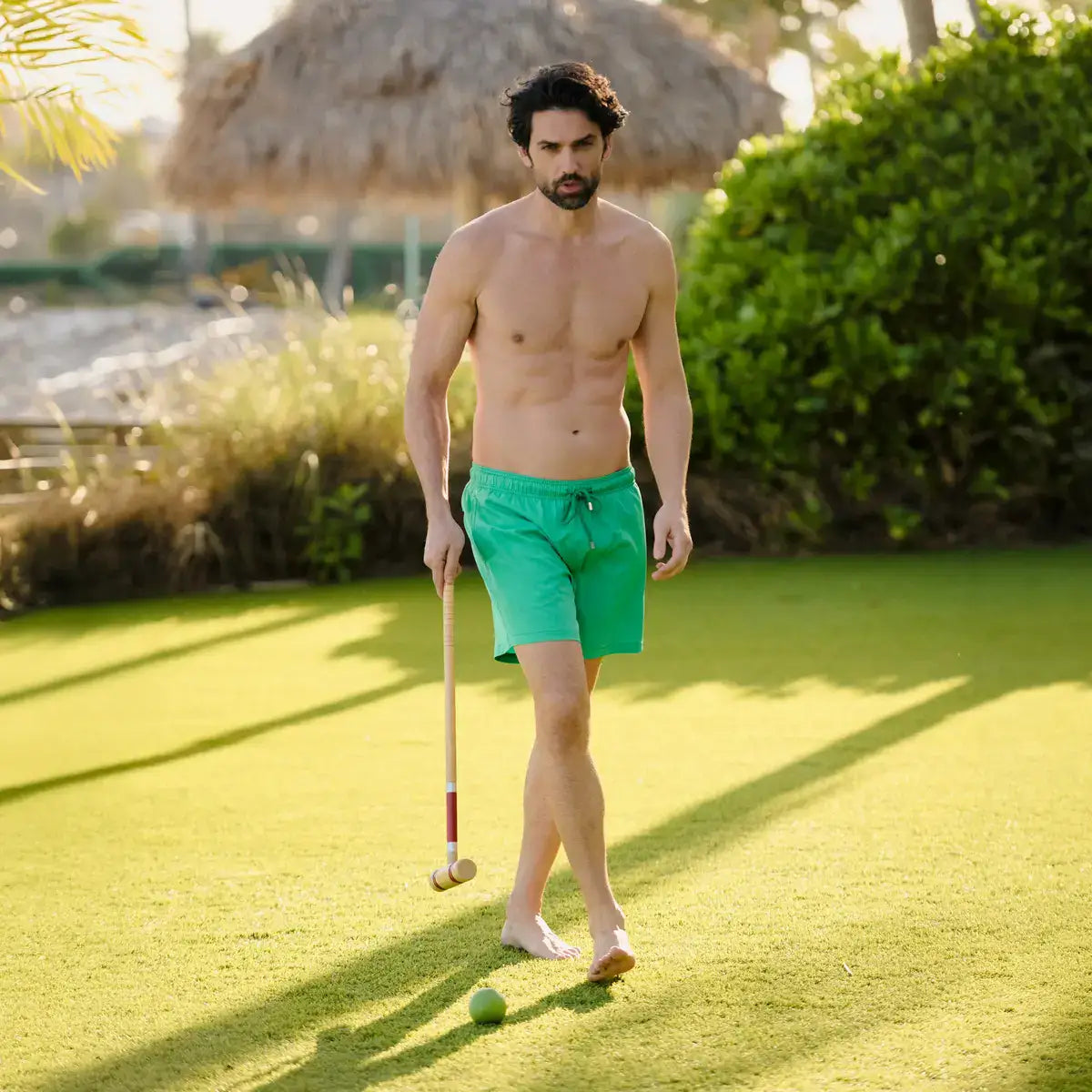 Man in Island Green hybrid swim shorts in solid jade green, outdoors