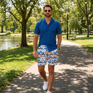 Man on a park path beside a pond in Line Rush Ocean and Sol hybrid swim shorts and an Ocean Blue resort shirt