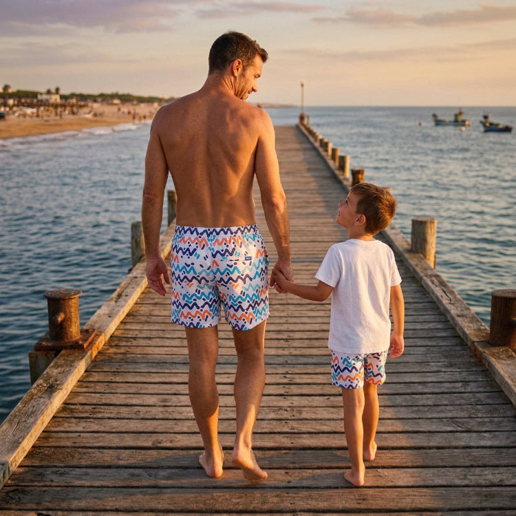 Man and child walking hand-in-hand on a wooden pier by the sea at sunset.