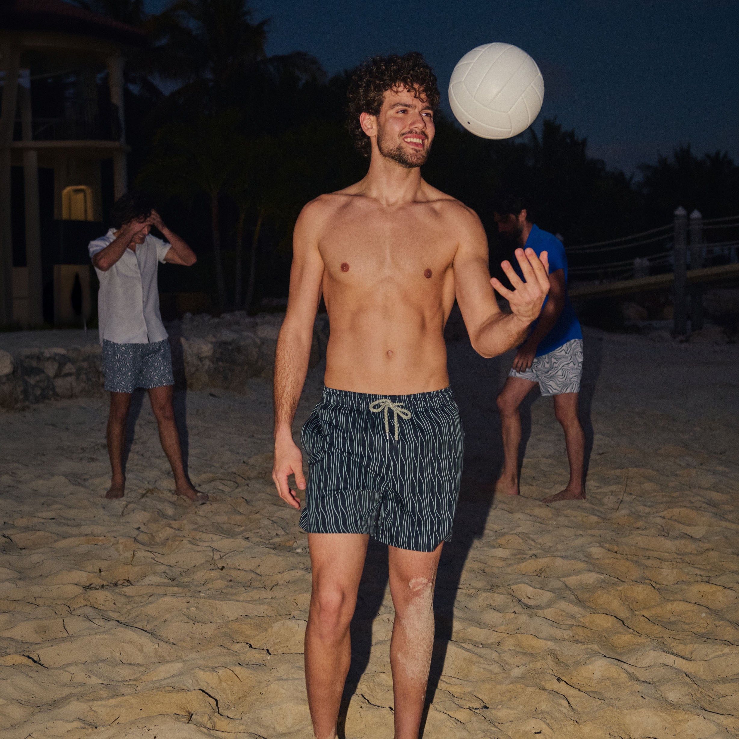 Man in Linear Drift Storm and Fog hybrid swim shorts, charcoal with a white wave stripe