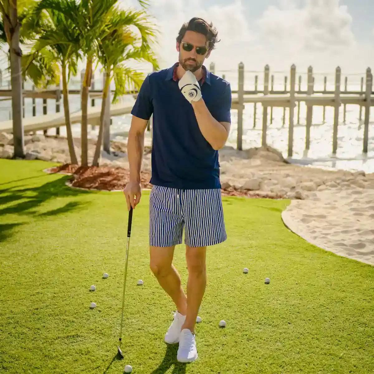 Man in Marina Pinstripe Indigo and Surf hybrid swim shorts, a navy and white pinstripe, outdoors