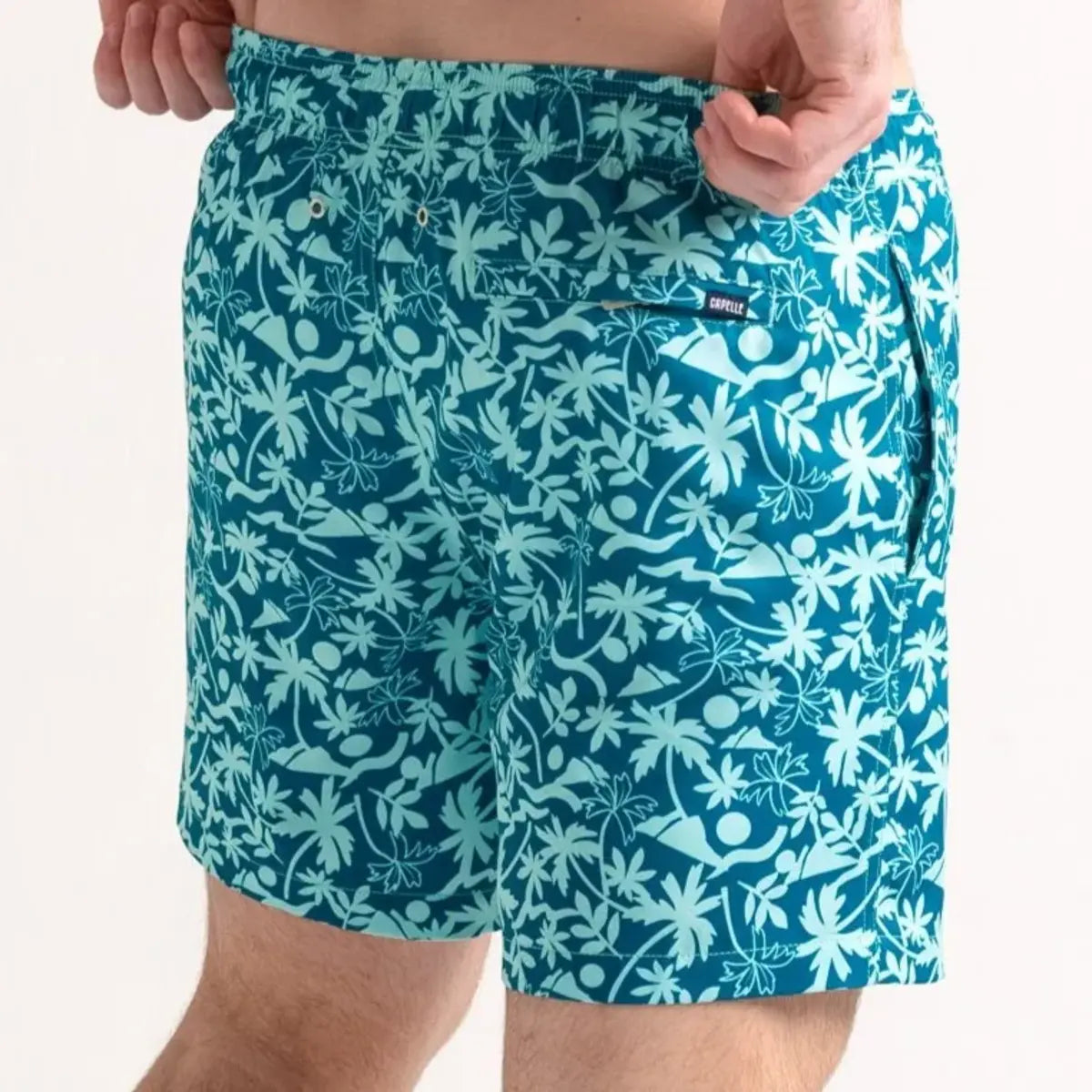 Oasis men's hybrid swim short in teal with a white tropical palm print, back view