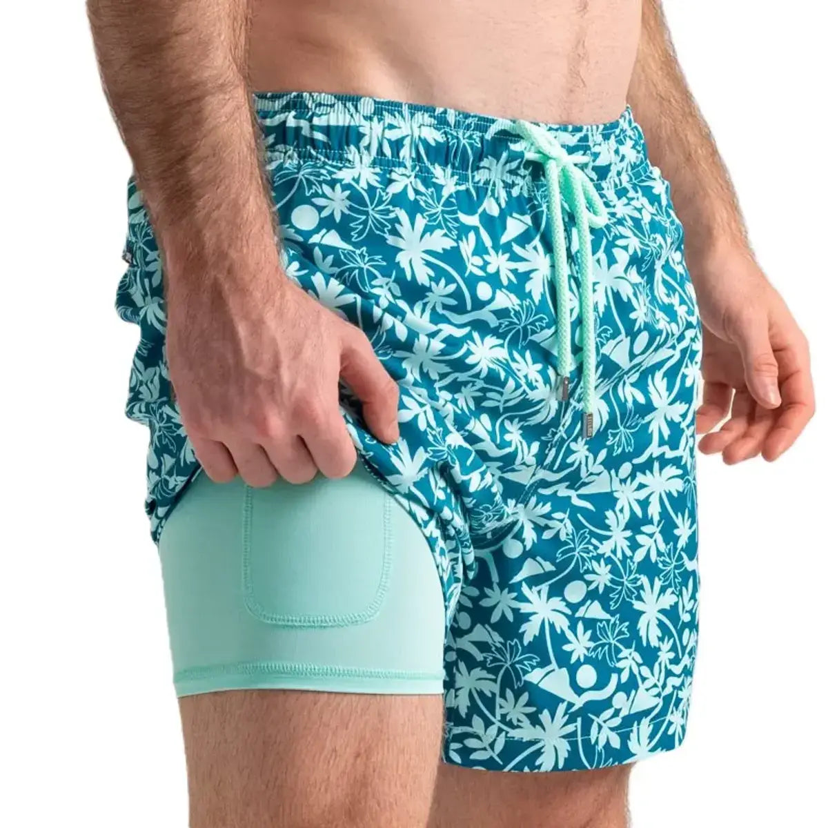 Oasis men's hybrid swim short, teal with a white tropical palm print and mint drawstring, front view showing the mint compression liner