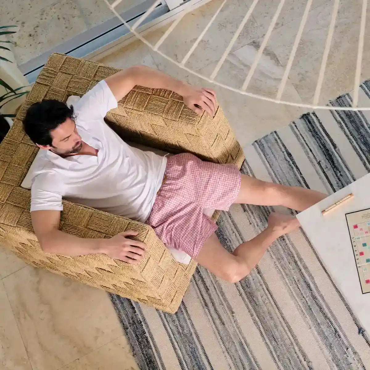 Man in Pixel Break Rosetide hybrid swim shorts, dusty pink with a tonal pixel grid check, at the water