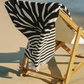 Ruby Mint Remington black and white floral stripe towel on a wooden beach chair