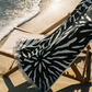 Ruby Mint Remington black and white floral stripe towel on a beach chair by the ocean