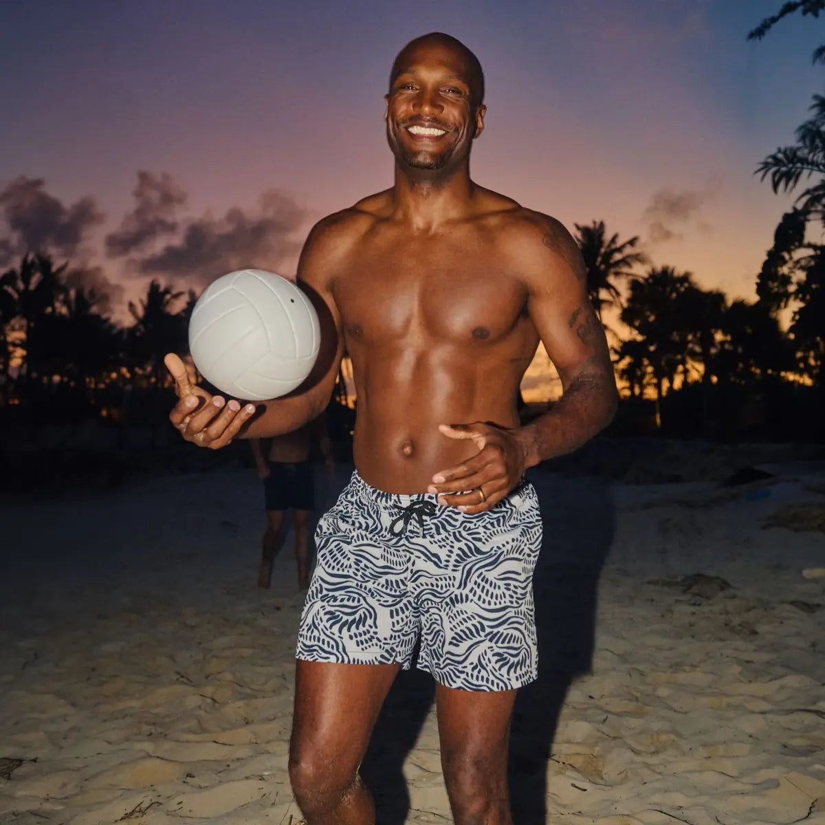 Man in Salt Spray Surf and Storm hybrid swim shorts, black with a white coral reef print