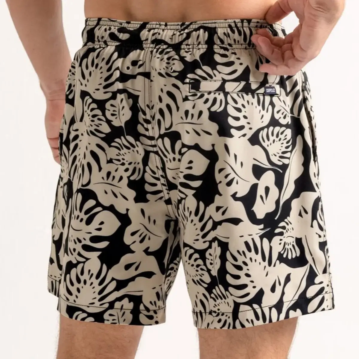 Tropical Garden men's hybrid swim short in black with a cream monstera leaf print, back view
