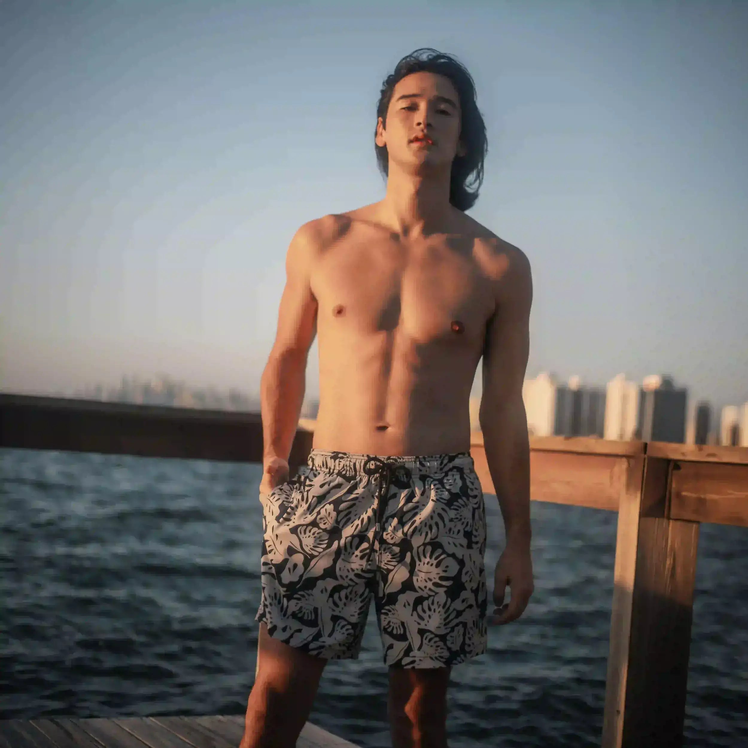 Man in Tropical Garden hybrid swim shorts, black with a cream monstera leaf print