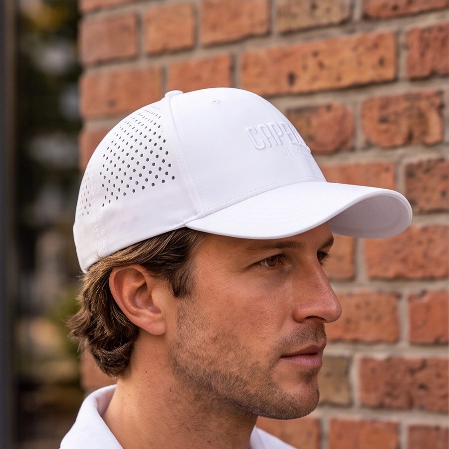 Arctic White Laser Luxe Performance Snapback Hat worn in profile showing laser perforated panels and curved visor, Capelle Miami